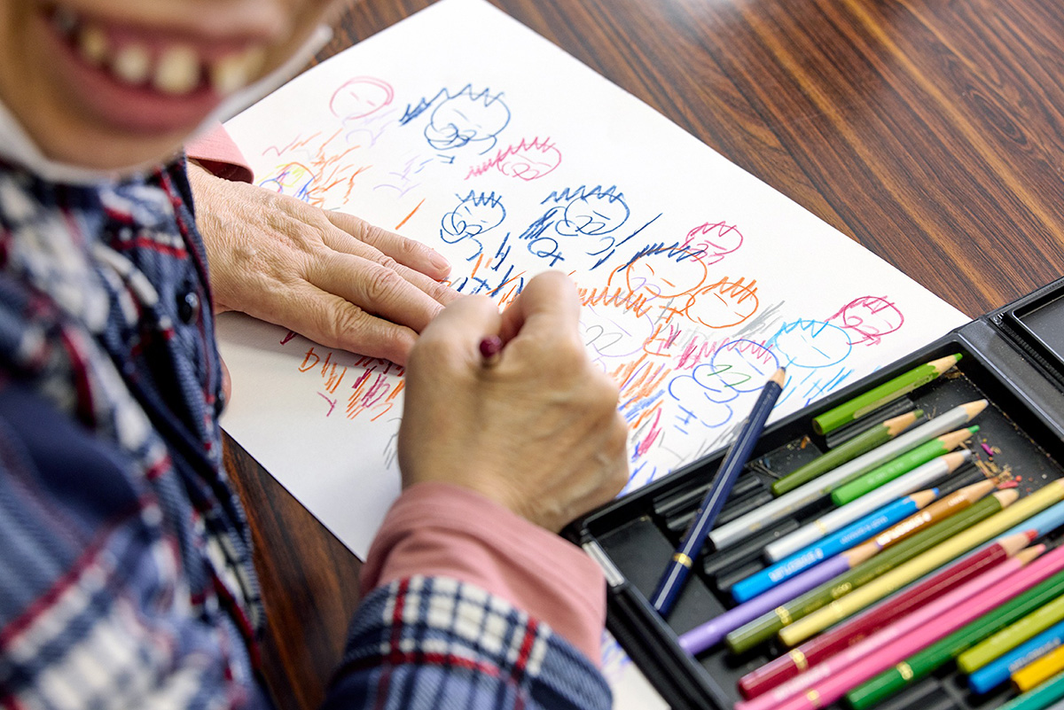 アトリエを訪れた人々の顔を描く富澤富士子さん