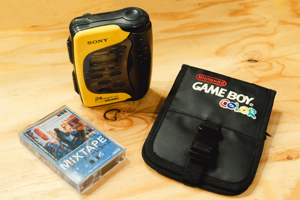 左から、ネオンシティレコーズの非売品ミックステープ、〈SONY SPORTS〉のカセットテープレコーダー、「ゲームボーイカラー」を持ち運ぶために作られたキャリーケース