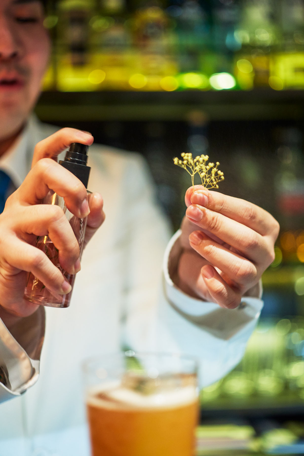 カスミソウに、桜リキュールの「KANADE〈奏〉桜」をスプレーする様子