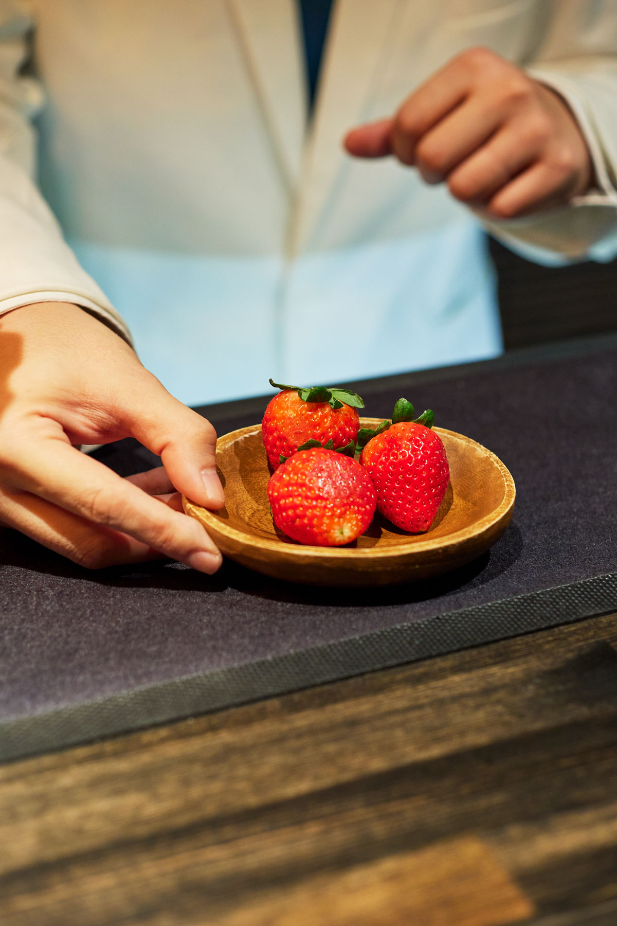 イチゴを持つ若林将太さんの手元