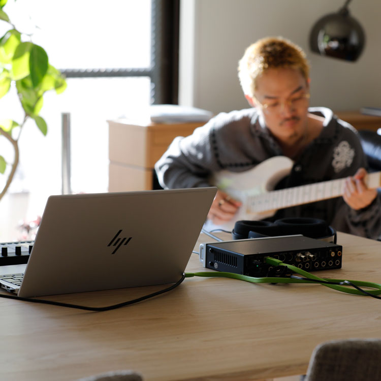 ギターを弾くShin Sakiura