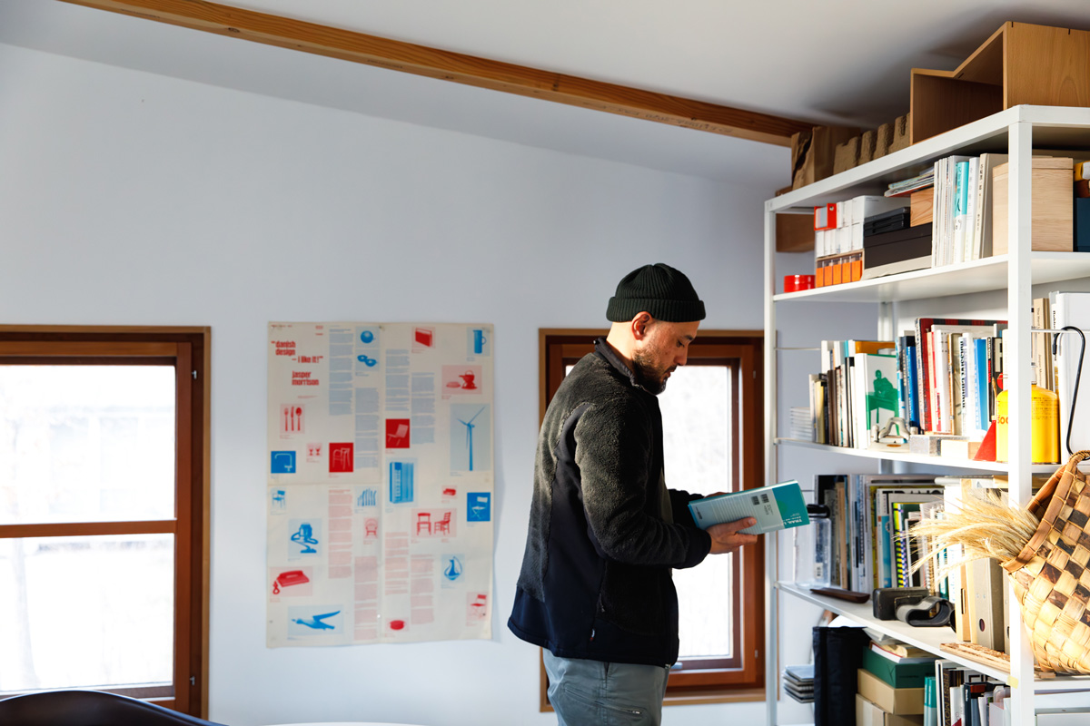 本棚の前に立つ熊野亘