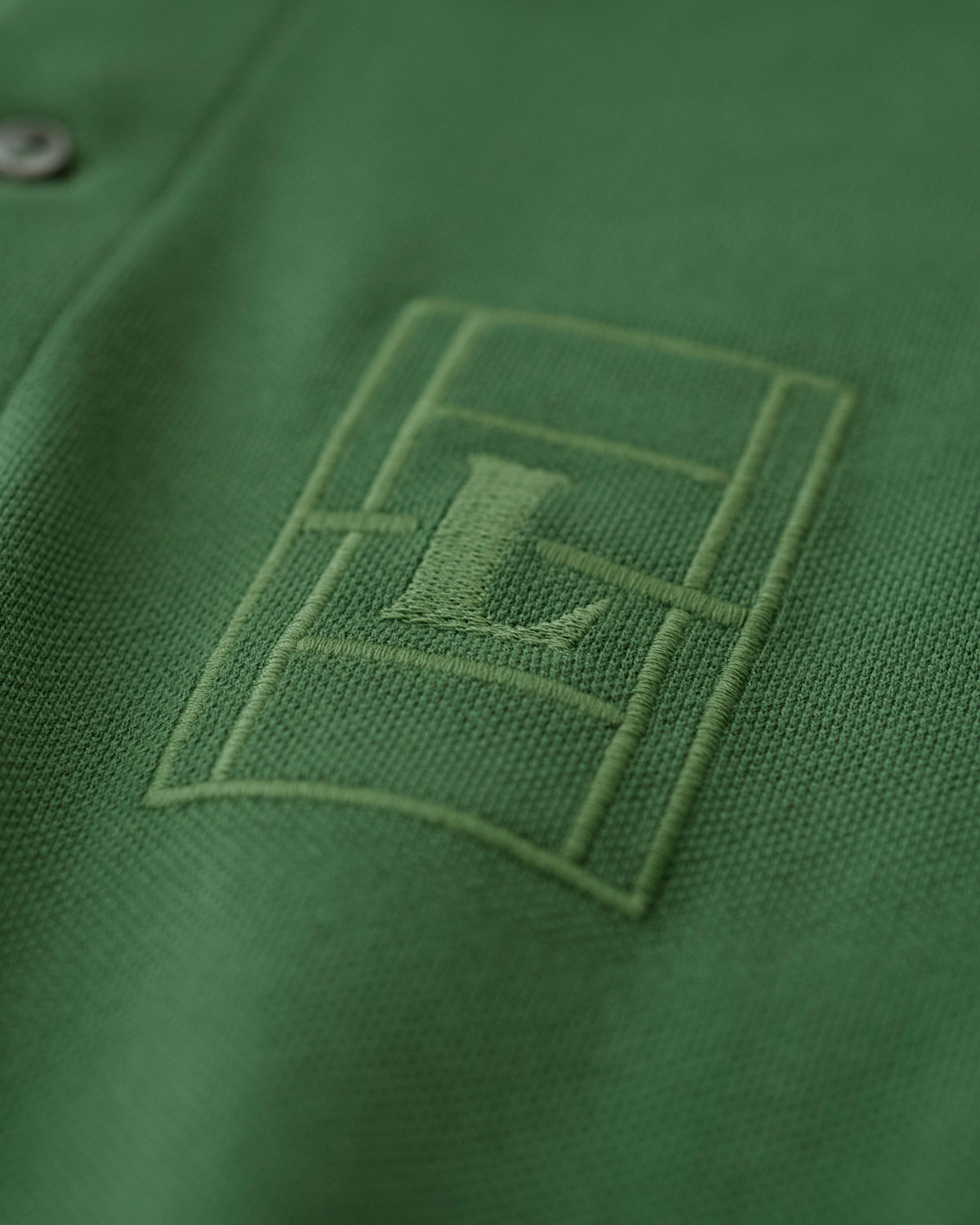 ラコステのテニスコートのエンブロイダリー入りポロシャツ