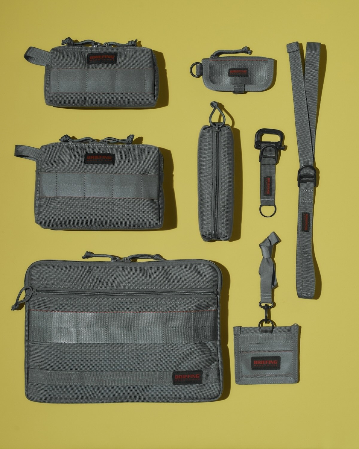 右上から／ベルト《W RING BELT》6,600円、キーケース《ZIP KEY CASE》（H7×W12.5×D1cm）8,800円、キーホルダー《KEY HOLDER》6,600円、ペンケース《PEN HOLDER》（H5×W20.5×D5cm）6,600円、IDケース《ID》（H10×W11.5cm）7,700円、モバイルポーチ Mサイズ《MOBILE POUCH M》（H10×W19×D4cm）17,600円、モバイルポーチ Lサイズ　《MOBILE POUCH L》（H14×W22×D4cm）18,700円、クラッチバッグ《A4 CLUTCH》（H24.5×W35×D1cm）26,400円（以上ブリーフィング／ブリーフィング 六本木ヒルズ店︎）