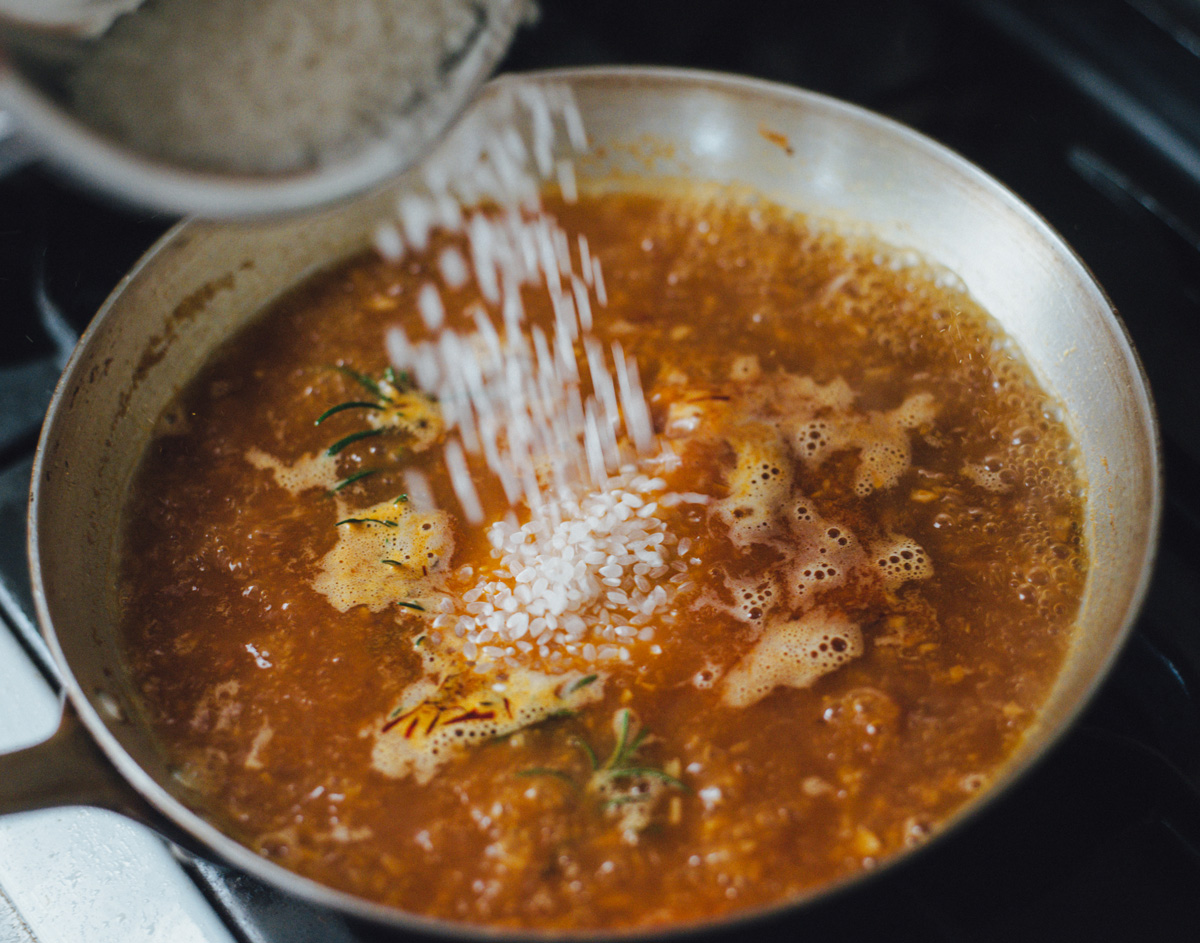 煮詰めてから水、ローズマリー、サフランを加える様子