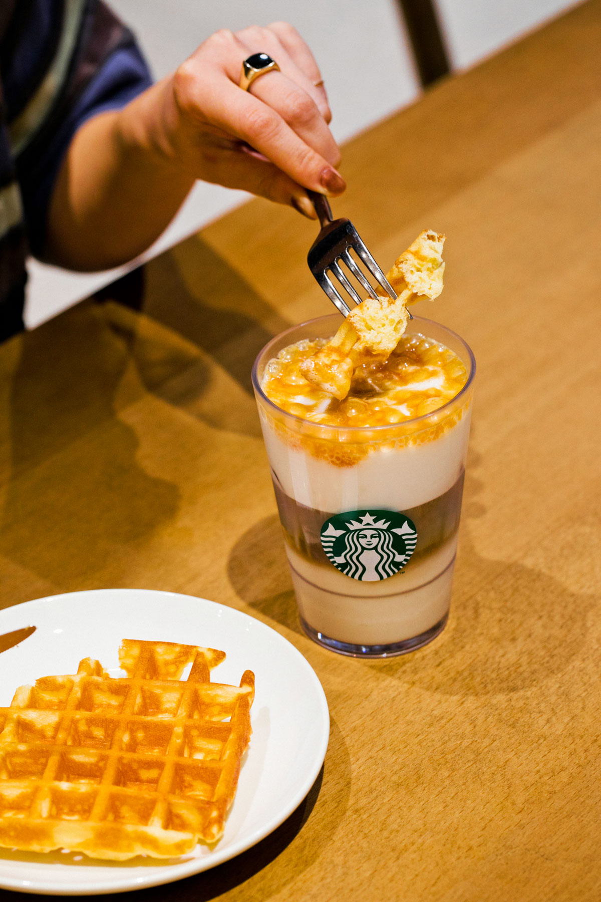 アメリカンワッフルをキャラメル・マキアートにディップする様子